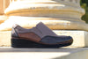 A brown and gray women's slip-on shoe with a low wedge heel.